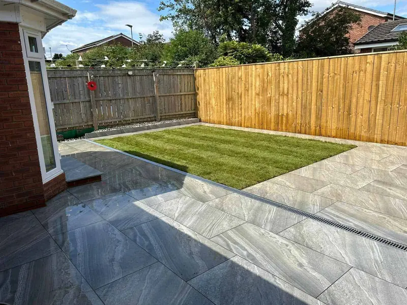 New close-board timber fence around a freshly turfed lawn and grey porcelain patio